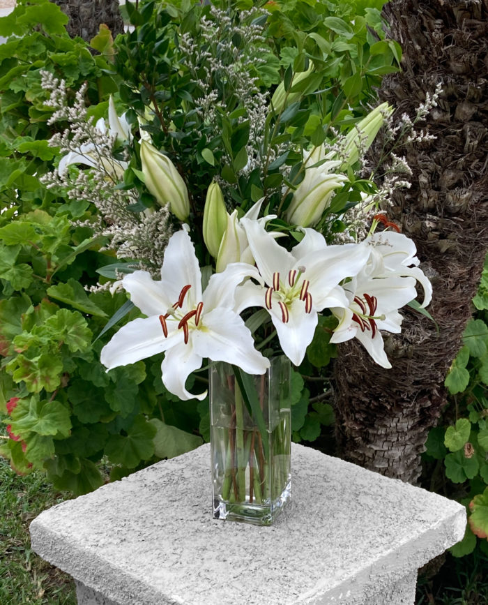 White lilies, Israeli ruscus, and babys breath floral arrangement by Bloom Parlor