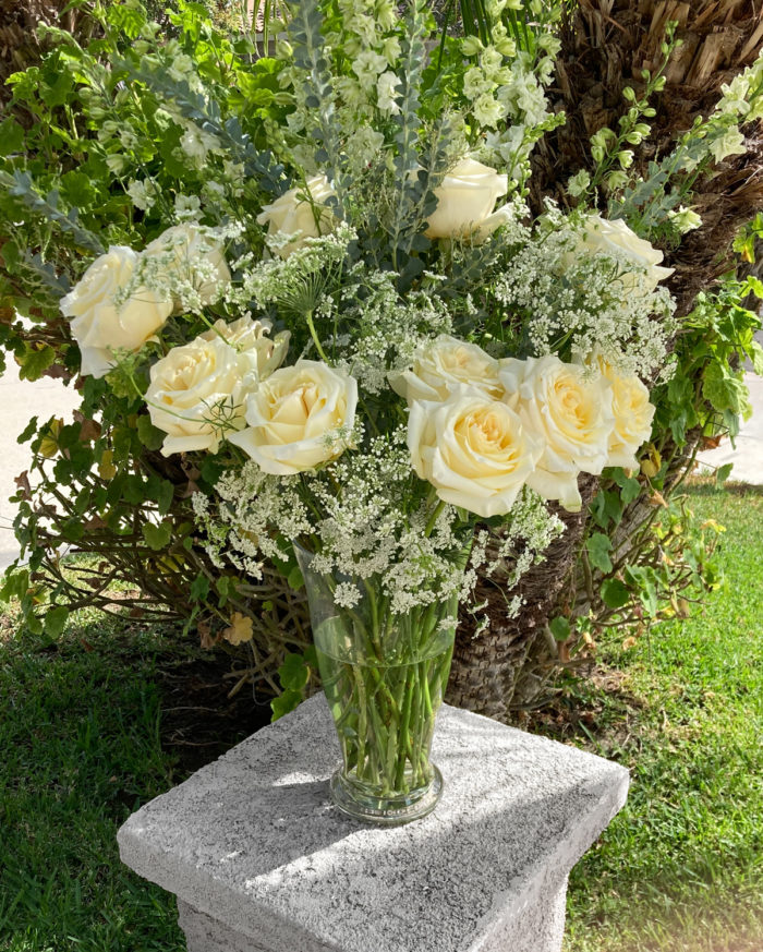 A Bloom Parlor sympathy and wedding floral arrangement with roses, eucalyptus, larkspur, and gypsophila.